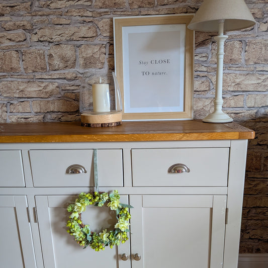 Key Lime Pie Wreath 20cm on a pale grey unit with a velvet green ribbon