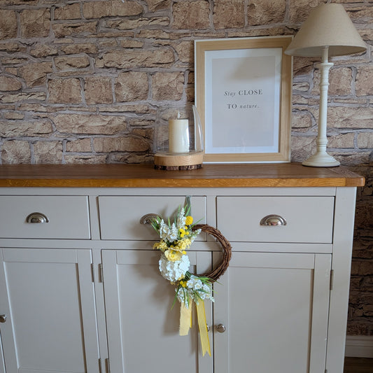 20cm Lemon Meringue Pie wreath shown against a pale grey side unit