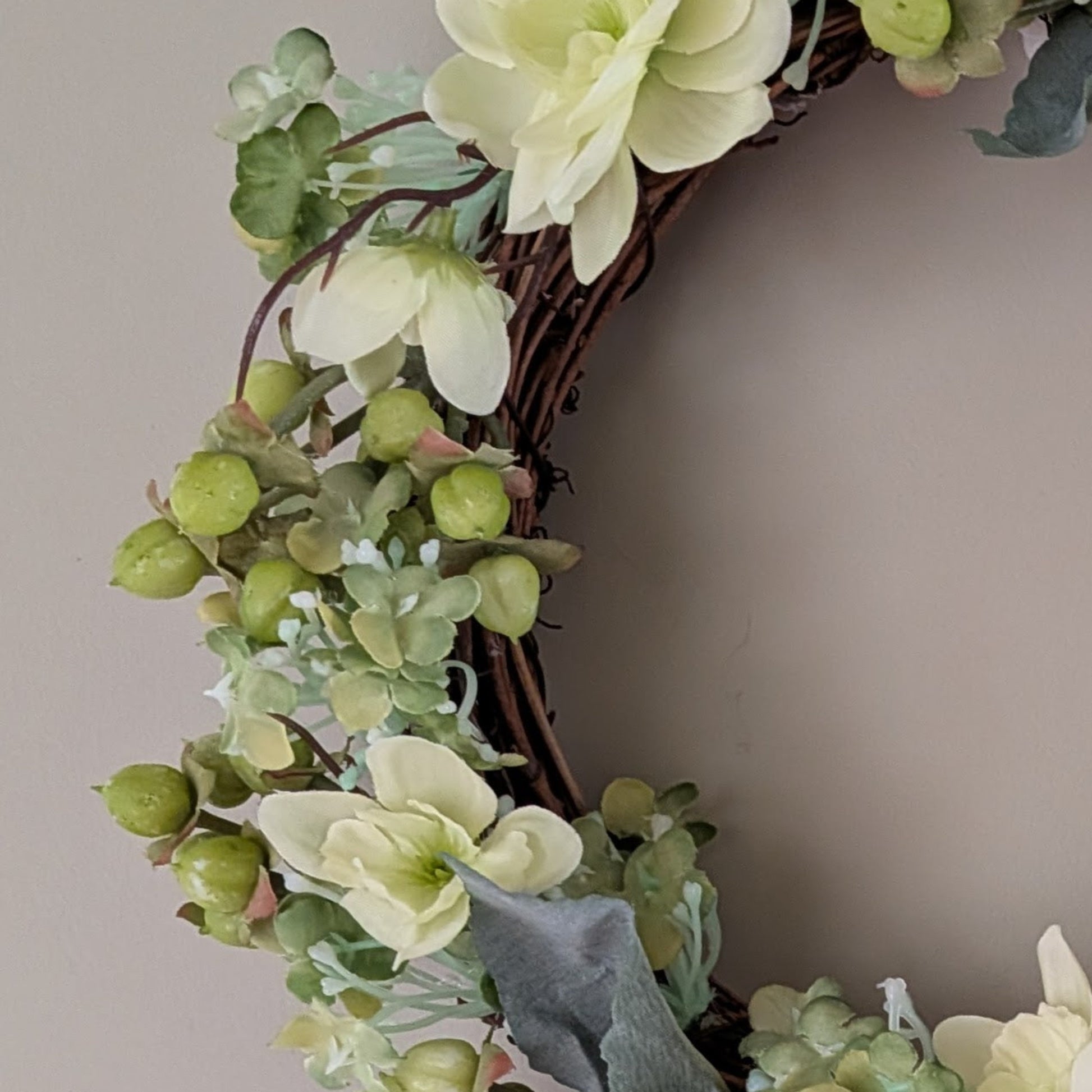 Close up of 20cm key lime Pie Wreath showing soft green faux florals and berries