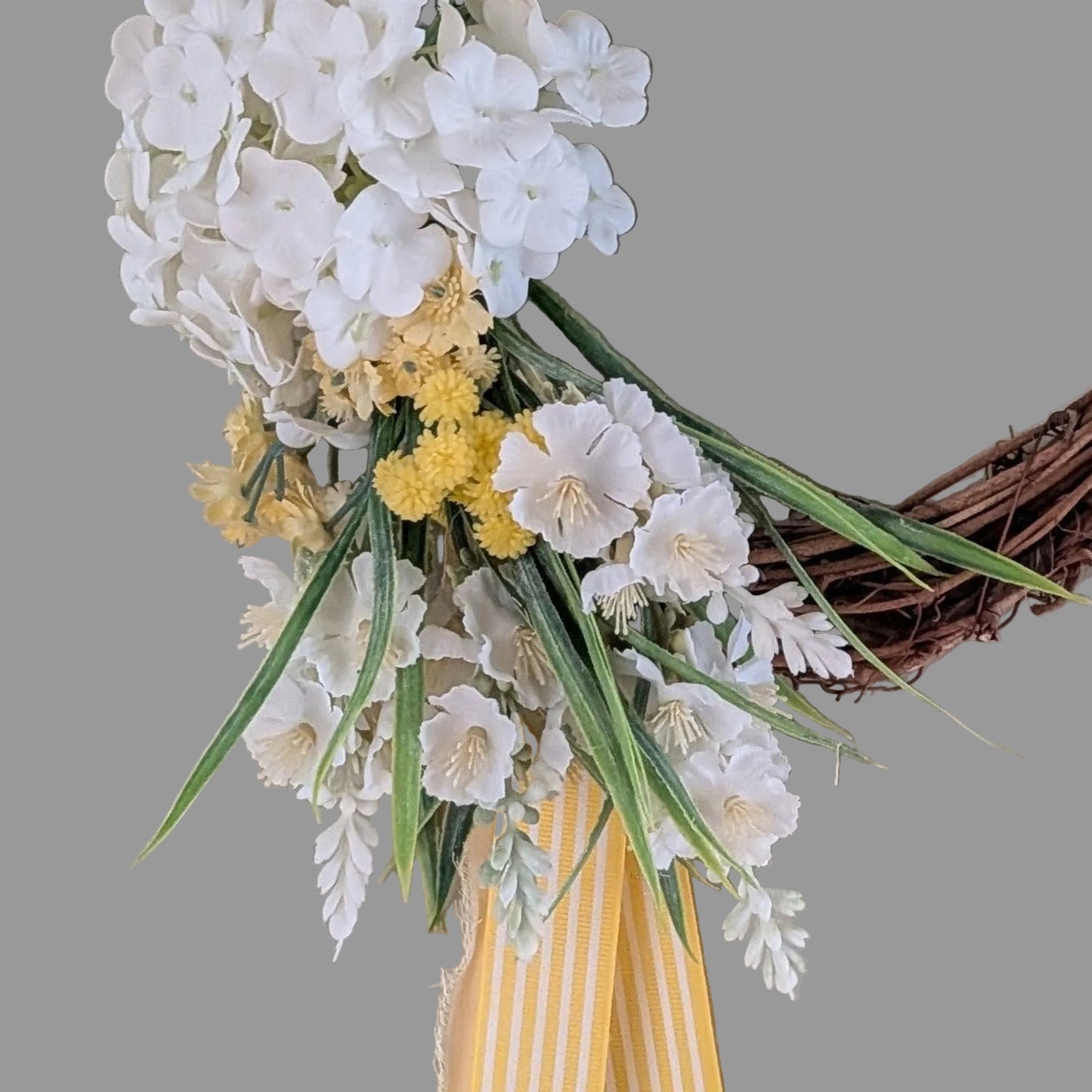 Close up detail of lemon and white faux flowers and  candy striped yellow ribbon and lemon chiffon ribbon