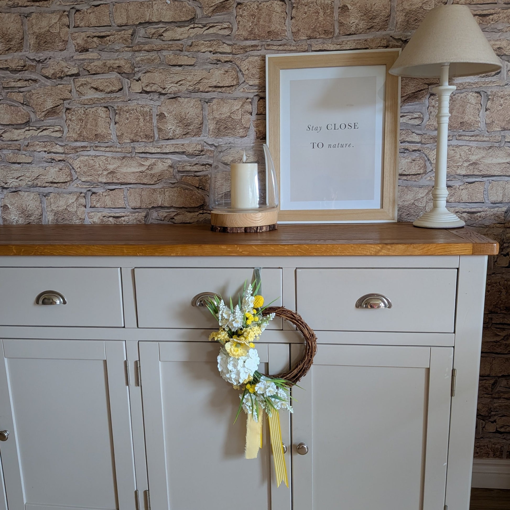 20cm Lemon Meringue Pie wreath shown against a pale grey side unit