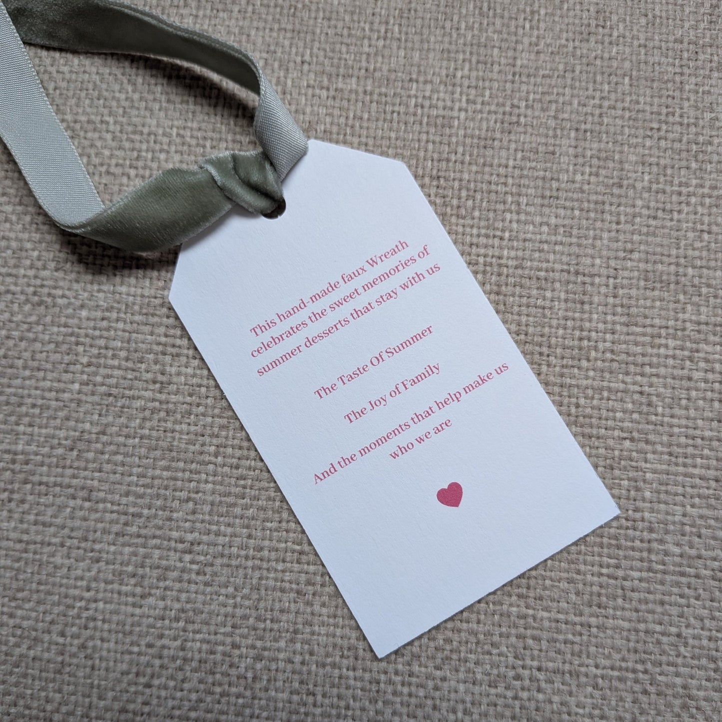 close up of the back of the Rhubarb & Custard tag with a sage green velvet ribbon
