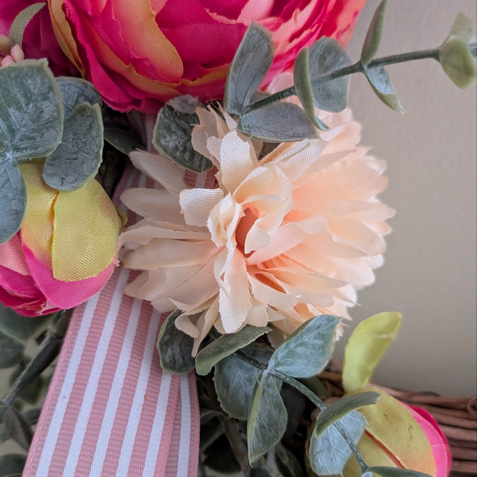 A close up of Rhubarb & Custard wreath 20cm - showing details of Faux custard and pink florals and a candy pink stripe ribbon 