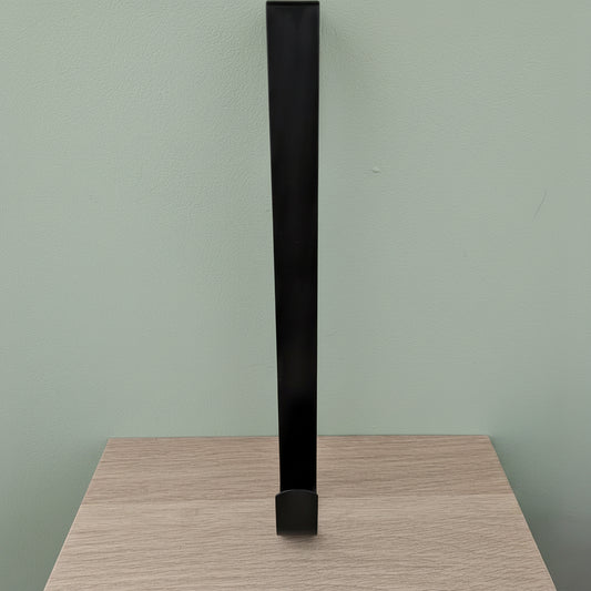 Black metal wreath hanger 30cm standing upright on light oak surface against sage green background