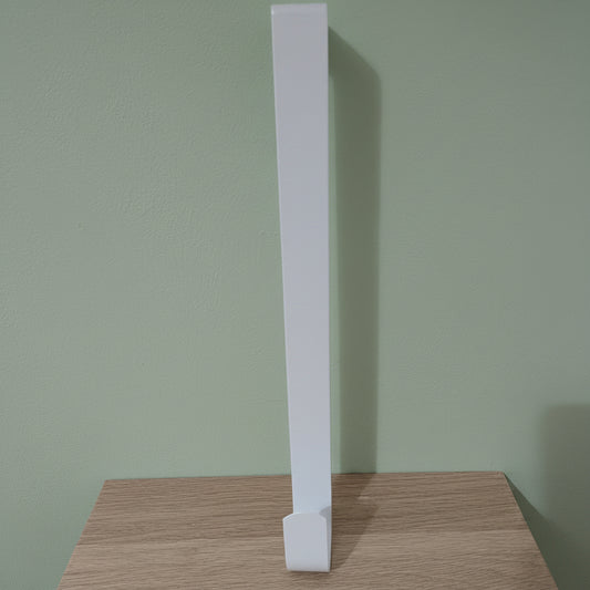 White metal wreath hanger 30cm standing upright on light oak surface against sage green background